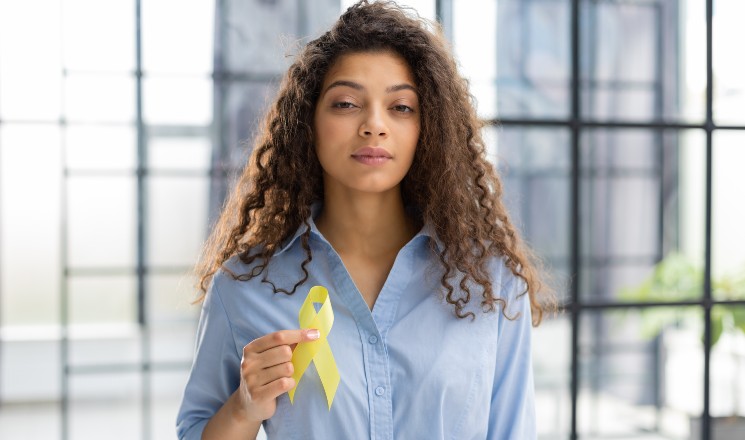 jeune femme portant un ruban jaune en soutien aux malades d'endométriose